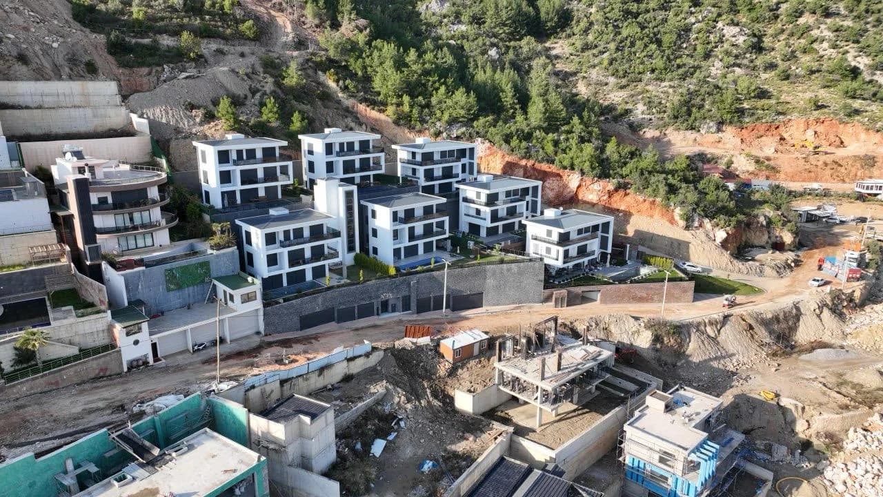 Aerial drone shot of the luxury Whate Villa residential complex in Tepe, Alanya, featuring modern villas for sale with panoramic views.